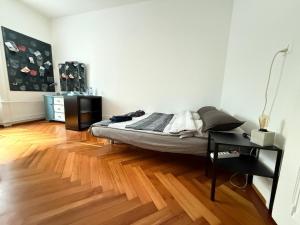 a bedroom with a bed and a wooden floor at Laus-Angeles in Lausanne