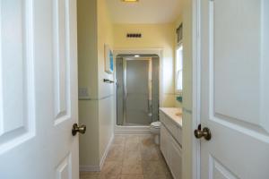 a bathroom with a toilet and a glass shower at Cupola House in Edisto Island +23 photos