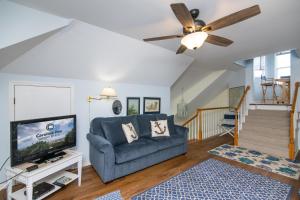 a living room with a blue couch and a tv at Cupola House in Edisto Island