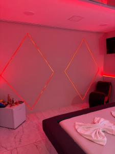 Habitación rosa con cama y mesa en Motel Ladakk, en Brasilia