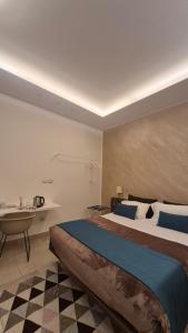 a bedroom with a large bed and a desk in it at VILLA GENTILE RESORT E SPA in Cassano delle Murge