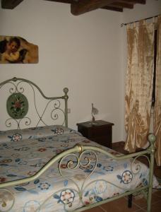 a bedroom with a bed with a floral bedspread at La Quiete in Acquapendente