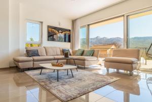 a living room with couches and tables and windows at Ferienhaus In Dugopolje Mit Privatem Pool in Dugopolje