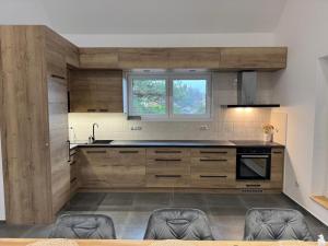 a kitchen with wooden cabinets and a sink at Chalupa u lesa Rasochy 83 in Uhlířská Lhota