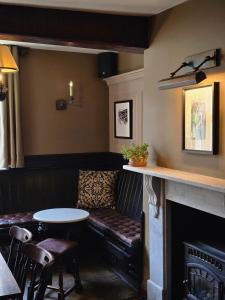 a bar with a couch and a table and a fireplace at Red Bull in Stockport