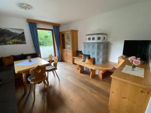 a living room with a table and a tv at Chalet Mühlbachl In Rohrberg Rohr in Zell am Ziller