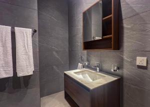 a bathroom with a sink and a mirror and towels at Anthonian Suites in Accra +44 photos