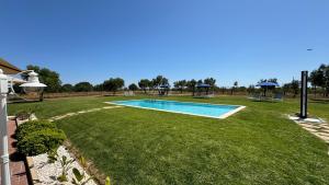 a swimming pool in a yard with a grass field at Vila Fuzeta Bed&Breakfast in Fuzeta +51 photos