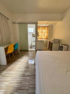 ein Hotelzimmer mit einem Bett und einem Tisch und Stühlen in der Unterkunft Apartamento 01 Vila Telebrasília in Brasilia