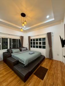 a bedroom with a bed with a black leather couch at SANDY HOUSE PAI 3bedroom in Kampong Huaibū