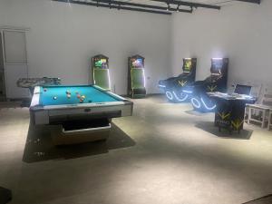 a room with three arcade games and a pool table at Hotel y Cabañas Parinzzi in Guatapé