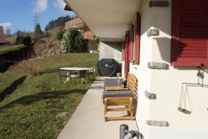 a patio with a table and chairs on a house at Abigrot in Hasliberg Wasserwendi