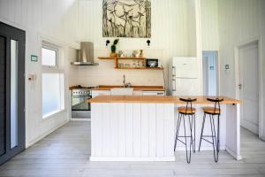 a kitchen with a counter and stools in it at BOG Nórdica 2 in Villa La Angostura