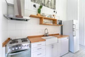 a kitchen with a sink and a stove and a refrigerator at BOG Nórdica 2 in Villa La Angostura