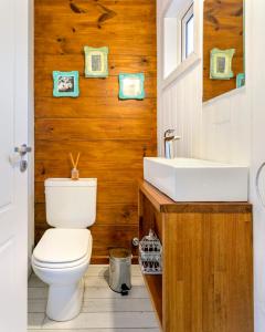 a bathroom with a white toilet and a sink at BOG Nórdica 2 in Villa La Angostura