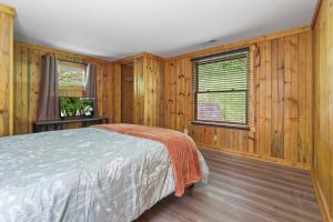 a bedroom with wooden walls and a bed in a room at Lakefront in Logan (In the heart of Hocking Hills) in Logan