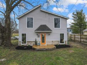 Buckeye LakeLuxury on Lakeside的院子里有一栋灰色的房子，门是橙色的。