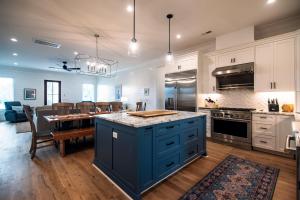 a large kitchen with blue cabinets and a dining room at Glory Be in Edisto Island