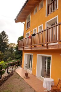 a yellow building with a balcony and a table at La Nave Monteggio in Monteggio