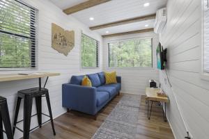 a living room with a blue couch in a tiny house at Hiltop Haven The Top Deck in Rockbridge