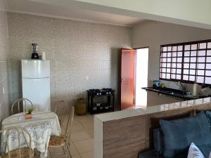 a kitchen with a table and a small table and a kitchen with a refrigerator at Casa Bela Vista II in São Roque de Minas