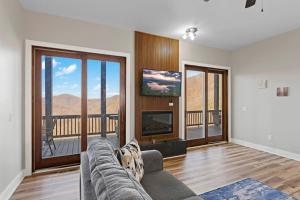a living room with a couch and a flat screen tv at Mountain View C - Mountain Stay, King Suite, Fireplace, and Mountain Views in Cullowhee