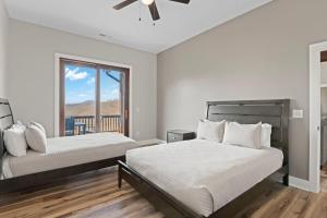 a bedroom with two beds and a balcony at Mountain View C - Mountain Stay, King Suite, Fireplace, and Mountain Views in Cullowhee