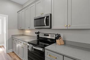 una cucina con fornelli e microonde di Mountain View D - Luxury Condo, King Suite, Amazing View, Peace, and Hiking a Cullowhee