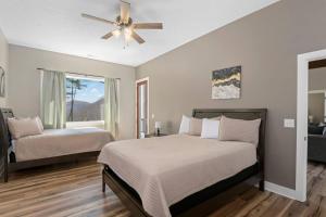 een slaapkamer met twee bedden en een plafondventilator bij Valley View B - Mountain Hideaway, Grill, and Sunset Views in Cullowhee