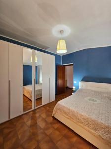 ein Schlafzimmer mit einem Bett und einer blauen Wand in der Unterkunft Esperia Holiday House in Castelpetroso