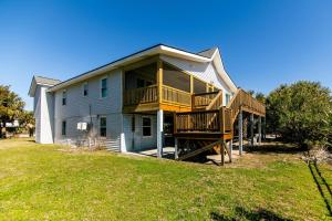 ein großes Haus mit einem Balkon und einer Terrasse in der Unterkunft Barefoot Bungalow in Edisto Island