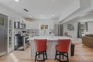 a kitchen with a white counter and two red chairs at The Landing Spot in Summit Station