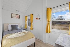 a bedroom with a bed and a window with yellow curtains at The Shack in Buckeye Lake
