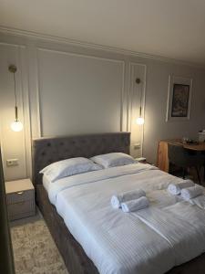 a bedroom with a large bed with two towels on it at Golden Sky Residence in Satu Mare