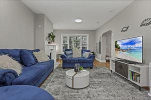 MiloThe Vibe At OSU的客厅配有蓝色的沙发和平面电视。