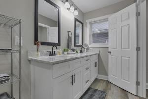 MiloThe Vibe At OSU的一间白色浴室，配有洗手池和镜子。 更多46张照片