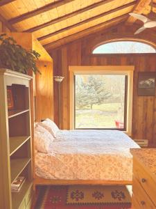 a bedroom with a bed and a window at Cozy Cottage in the Tetons in Driggs