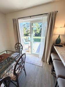 a dining room with a glass table and chairs and a window at Normandy Breeze in Wilmington