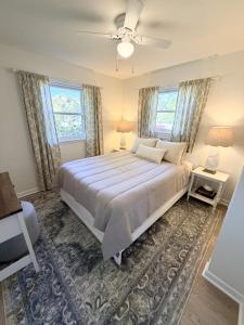 a bedroom with a large bed and two windows at Normandy Breeze in Wilmington
