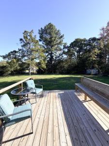 a wooden deck with a bench and a table at Normandy Breeze in Wilmington