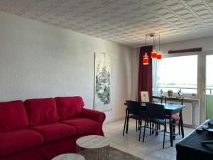 a living room with a red couch and a table at Central Studio for 2 in Hattersheim