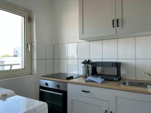 a kitchen with white cabinets and a sink at Central Studio for 2 in Hattersheim +1 photo