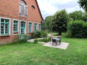 une table et des chaises devant un bâtiment en briques dans l'établissement Wohnung In Dreveskirchen Mit Kleinem Garten, à Blowatz