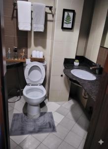 a bathroom with a toilet and a sink at The Runway Inn - Mactan Cebu in Mactan