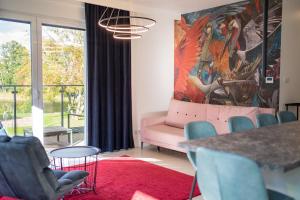 ein Wohnzimmer mit einem rosa Sofa und einem roten Teppich in der Unterkunft Marina Waterfront - najlepszy widok na Jeziorak in Iława
