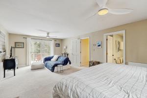 a large bedroom with a bed and a chair at Private Waterfront Retreat in Edgecomb