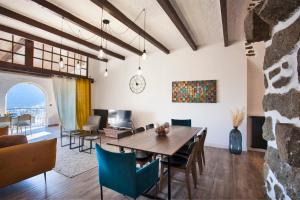 a dining room and living room with a table and chairs at Casa Lisa - appartement dans le village de Monticello vue mer in Monticello