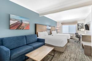 a hotel room with a couch and a bed at Best Western Plus Airport Inn & Suites in Salt Lake City