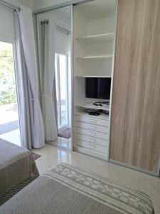 a large mirror in a bedroom with a television at Garcida in Governador Celso Ramos
