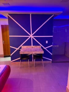 un banco de madera frente a una pared morada en Motel Ladakk, en Brasilia